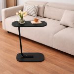 Modern C shape sofa side table with wood top and metal frame used beside a sofa in a living room