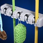 Wall mounted broom and mop holder organizer with 5 slots and 6 hooks for storing cleaning tools neatly and securely