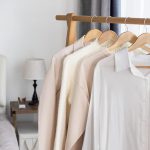 Three-piece natural wooden hanger set with rotating chrome hooks for organizing clothes, coats, suits, and dresses in the wardrobe