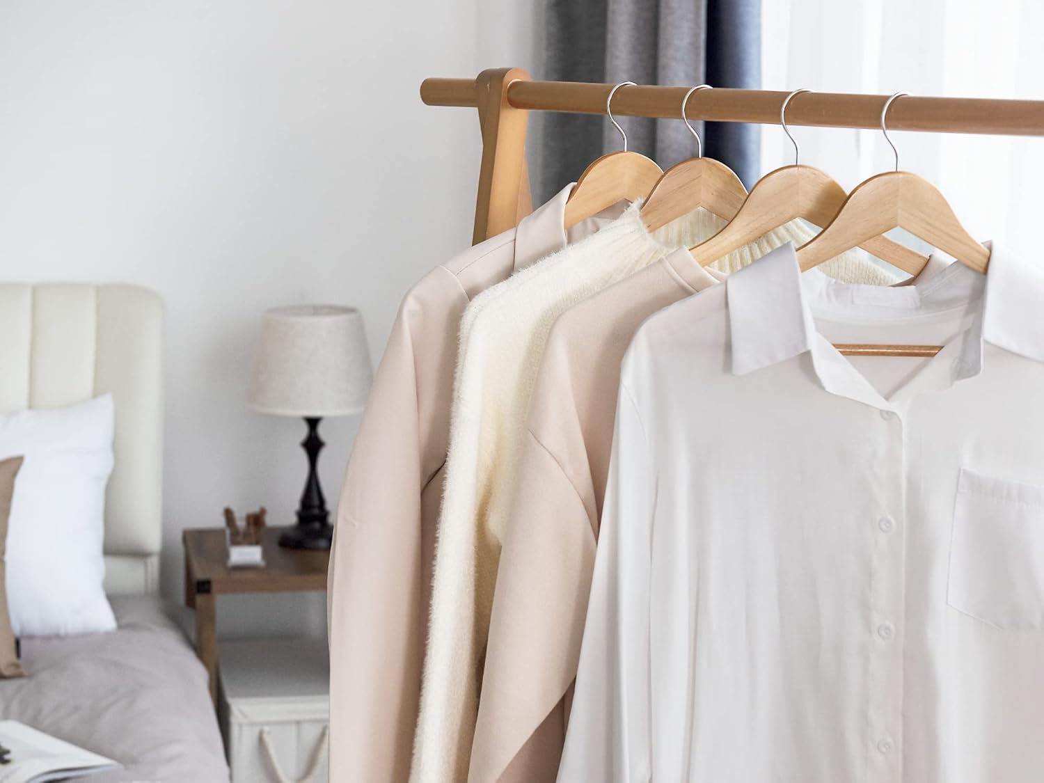 Three-piece natural wooden hanger set with rotating chrome hooks for organizing clothes, coats, suits, and dresses in the wardrobe