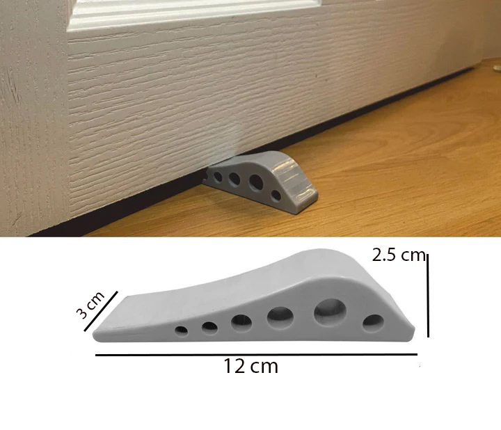 Grey rubber door stopper wedge with honeycomb non-slip design placed under door on wooden floor for secure door holding