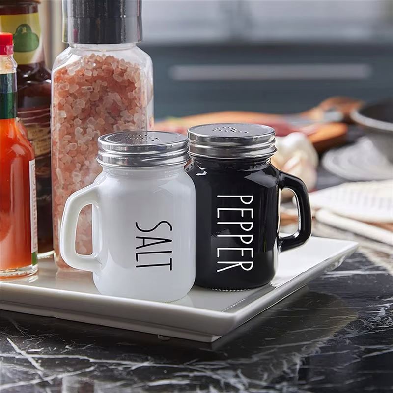 2-piece mug shaped salt and pepper shaker set made of glass with handle in black and white for modern kitchen and dining table