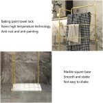 Freestanding towel rack with marble base, mesh laundry basket, and multiple towel rails in gold and black finish for bathroom organization