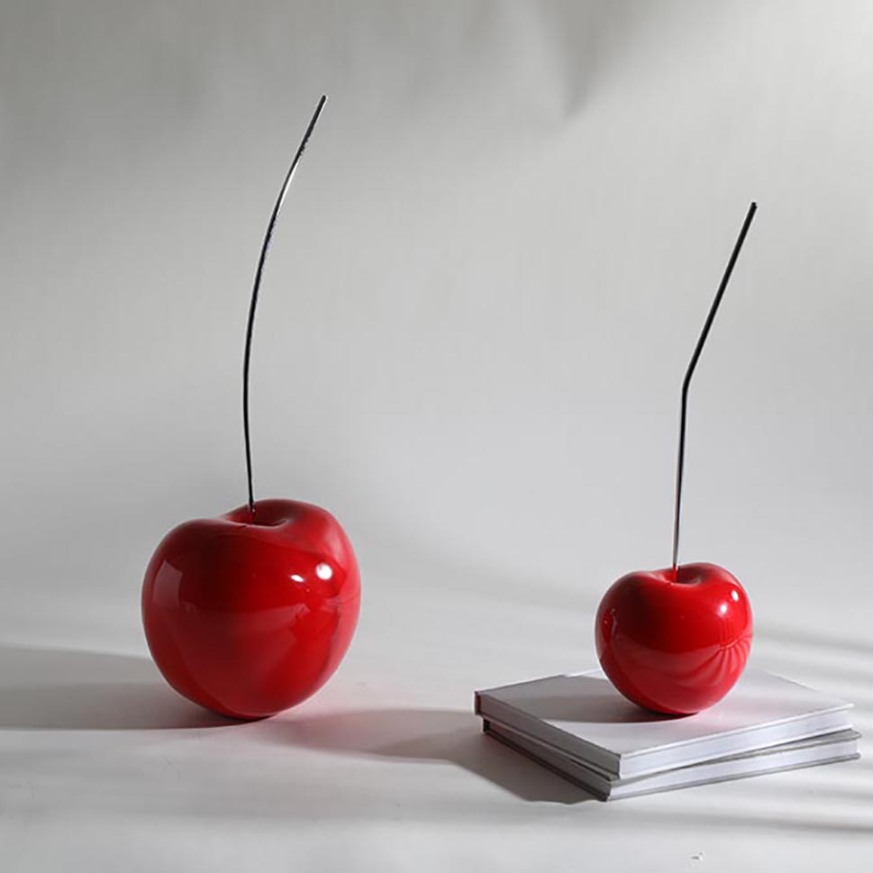 Glossy red ceramic cherry sculpture decorative piece on table in modern living room