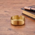 Gold stainless steel cigarette ashtray with fluted grooves and compact round design for home or bar use – shop now from Homedash in Lebanon.