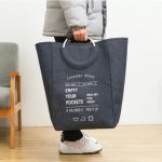 laundry basket with soft grip handles and laundry inside on white background