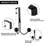 Black metal over the door hanger hook holding a handbag, space-saving door hook organizer for coats, bags and towels.