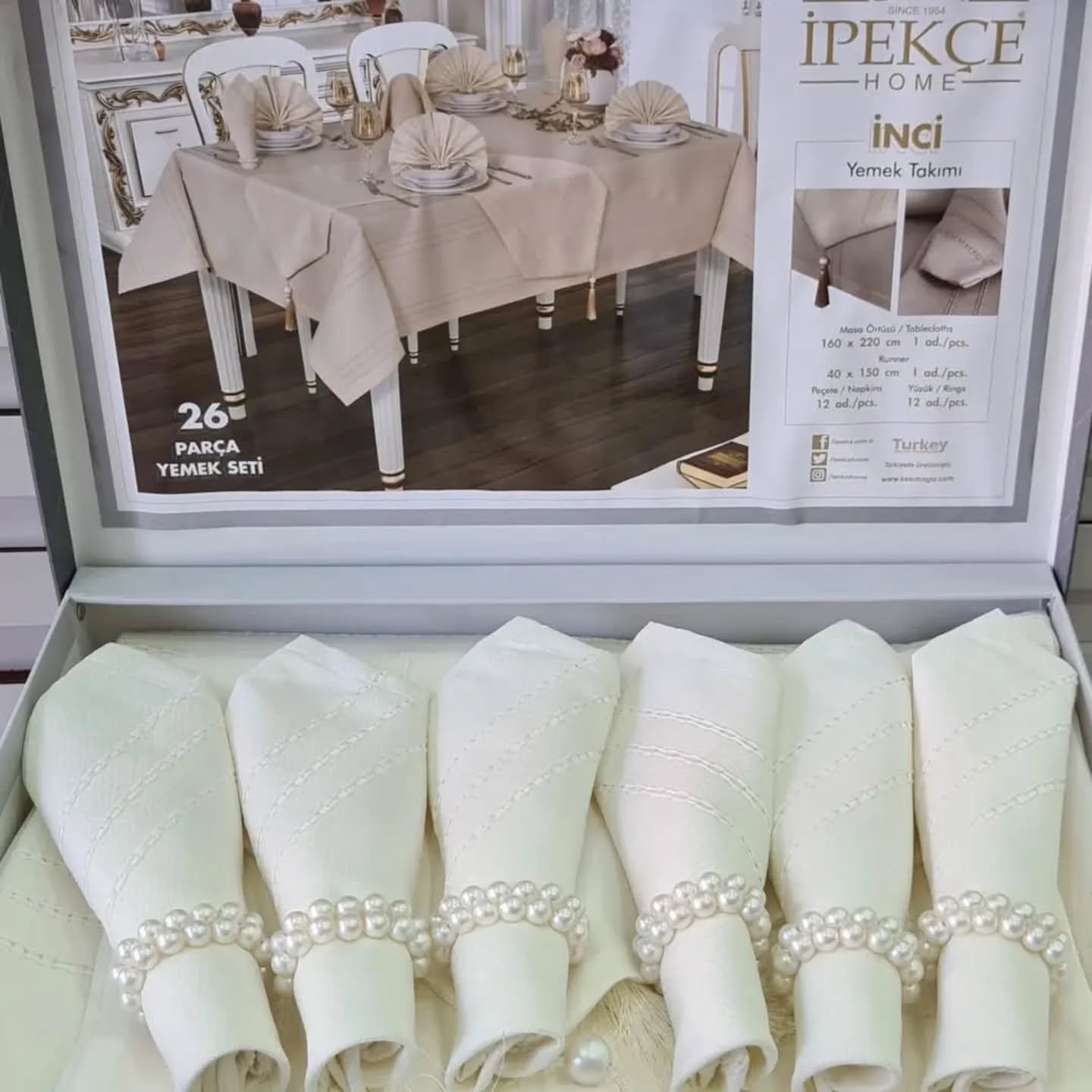 26-piece dinner table set with linen tablecloth, runner, napkins and pearl rings in light grey on white background