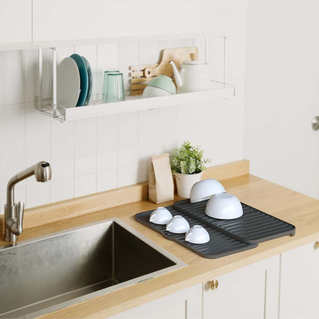 Expandable tabletop dish dryer rack with drainage spout and tiered surface in white and grey for kitchen use