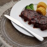 Set of 3 stainless steel dinner knives with ergonomic handle on white background