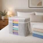 Cloth bag, Grey striped storage bag with transparent window filled with folded towels on white background