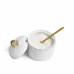 sugar bowl with lid and gold spoon on a clean white background, elegant modern design