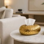 Luxury gold egg-shaped decorative tissue box with glossy reflective finish and black interior on white background.
