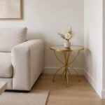 Luxury Cornet gold accent table with tempered mirror glass top and butterfly-inspired metal base for modern living rooms and bedrooms.