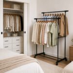 black double rod plastic garment rack with 4 wheels for hanging clothes and organizing garments in bedrooms or laundry rooms.