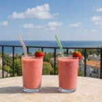 Reusable colorful glass smoothie straws set with 6 bent glass straws and cleaning brush on white background.