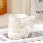 ceramic mug with textured finish and light blue 3D ribbon handle for coffee and tea.