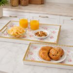 Set of 2 white rose serving trays with gold handles and decorative gold rim made from durable plastic.