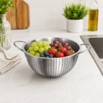 punching colander with side handles for washing vegetables, fruits, rice, and draining pasta.
